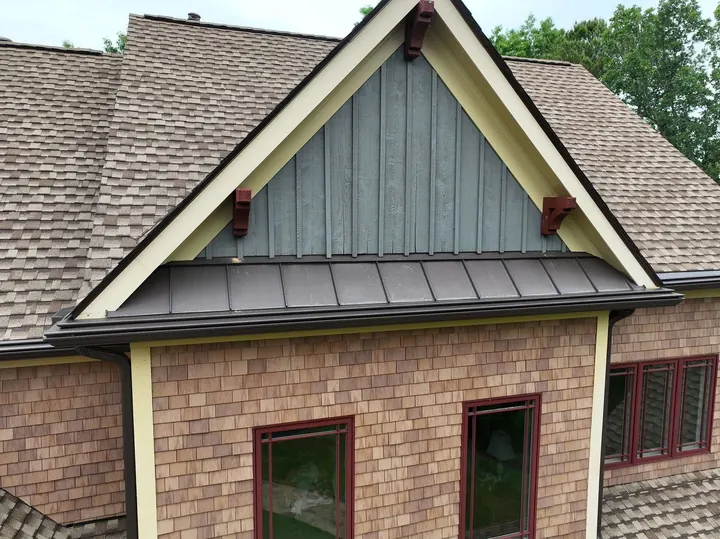 Gable roof with standing seam metal accent and gutter guards